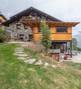 een blokhut met een balkon erboven bij Agriturismo La Clochette in Torgnon