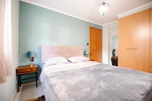 a bedroom with a large bed and a wooden cabinet at Alexandros Apartments in Paralía Proastíou