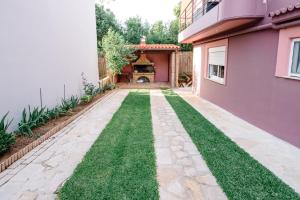 a garden with a lawn in front of a house at Alexandros Apartments in Paralía Proastíou