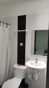 a bathroom with a white toilet and a sink at Hotel Bellagio in Barrancabermeja