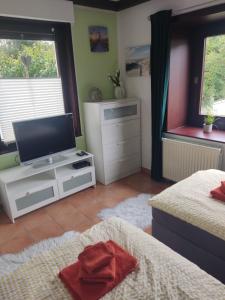 a bedroom with two beds and a flat screen tv at Ferienwohnung Zollverein in Essen