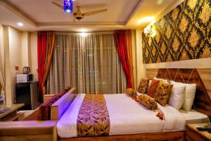 a bedroom with a large bed in front of a window at Swat Hilton Hotel by Khan Familia in Swat