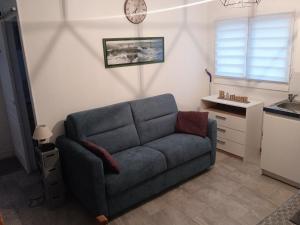 ein Wohnzimmer mit einem Sofa und einer Uhr an der Wand in der Unterkunft Capucine 
