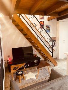 ein Wohnzimmer mit einer Treppe und einem TV in der Unterkunft LA MARIEFACTURE - Comme dans les étoiles in Boulay - Moselle