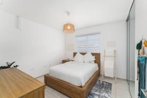 um quarto branco com uma cama e uma mesa em Casa Catalina - 11 min from BQN em Aguacate