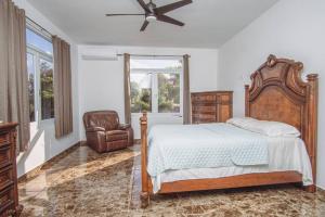 um quarto com uma cama e uma cadeira em Casa Blanca Mountain and Ocean Views em Rincon