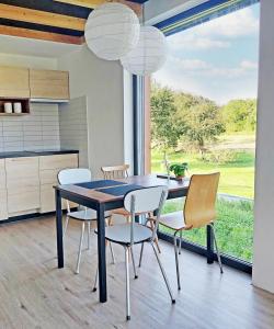 uma sala de jantar com uma mesa e cadeiras e uma janela em Small house in a nature park em Log pri Brezovici
