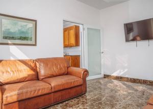 um sofá de couro castanho numa sala de estar com televisão em Casa Blanca Mountain and Ocean Views em Rincon