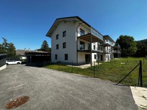 ein großes weißes Gebäude mit einem Zaun davor in der Unterkunft Apartment Seekind by Cosy Homes in Reifnitz