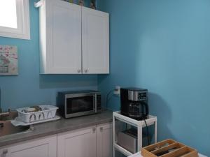 a kitchen with white cabinets and a microwave at Amor Bayridge in Kingston