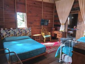 Schlafzimmer mit einem Bett, einem Schreibtisch und einem TV in der Unterkunft La Troje Cabañas in Tepoztlán