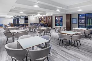 a restaurant with tables and chairs in a room at Holiday Inn & Suites Stillwater-University West, an IHG Hotel in Stillwater
