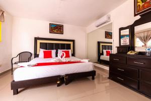 a bedroom with a large bed with red pillows at Hacienda Ixtlan Cozumel in Cozumel
