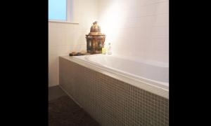 a bath tub in a bathroom with a window at Alberti - Bed & Bike in Rotterdam