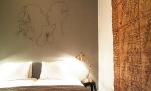 a bedroom with a bed with a drawing on the wall at Alberti - Bed & Bike in Rotterdam