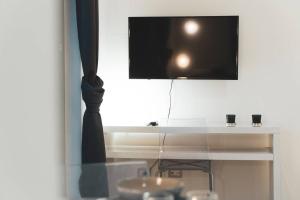- une télévision assise au-dessus d'une table blanche dans l'établissement Cas'aPina apartment, à Aci Bonaccorsi