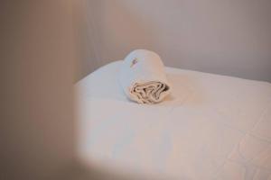 a roll of towels sitting on top of a bed at Cas'aPina apartment in Aci Bonaccorsi