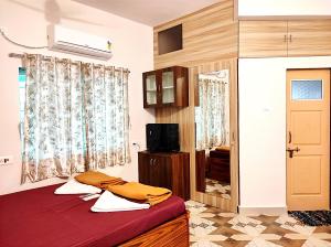a bedroom with a bed and a tv and a window at Suncrest Wood Stayz in Alibaug