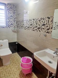 a bathroom with a sink and a toilet at Suncrest Wood Stayz in Alibaug