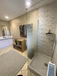 a bathroom with a glass shower with a sink at LA MARIEFACTURE - Comme à la Caserne 