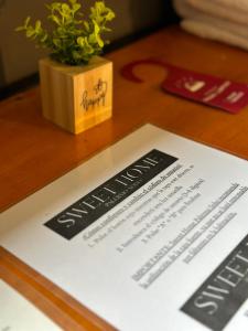 a menu on a wooden table with a plant at Hostel Sweet Home Palermo Soho in Buenos Aires +17 photos