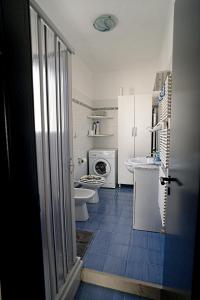 een badkamer met 2 toiletten, een wastafel en een wasmachine bij Leitmotiv Ospitality House in Bari