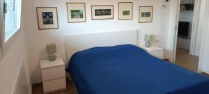 a bedroom with a blue bed and pictures on the wall at Bilocale a Rho in classe A in Rho