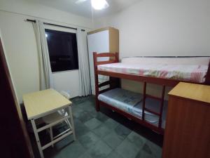 1 dormitorio con 2 literas y ventana en Apartamento - Praia do Tombo, en Guarujá