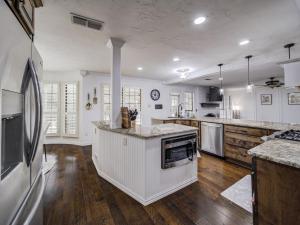a large kitchen with white appliances and wooden floors at Trophy Haven Retreat With Pool in Roanoke