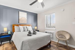 a bedroom with a bed with a chair and a ceiling fan at Dry Dock Inn in Carolina Beach