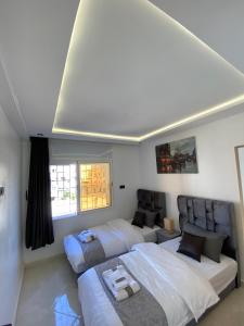 a bedroom with two beds and a couch at Lovely 2 bedroom apartment in Rabat