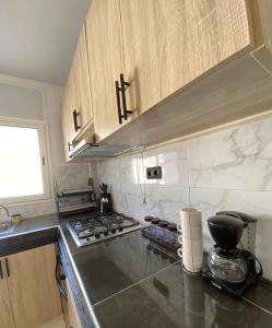 a kitchen with a stove top and wooden cabinets at Lovely 2 bedroom apartment in Rabat