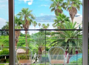 balkon z palmami i widokiem na ocean w obiekcie Dombe Resort w mieście Seogwipo
