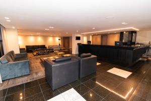 a lobby with couches and a bar in a building at Slaviero Hotel Curitiba Shopping in Curitiba