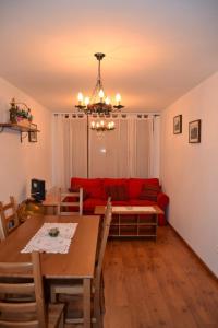 un soggiorno con divano rosso e tavolo di Apartamento en picos de europa a Carreña de Cabrales