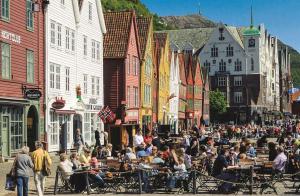 a crowd of people sitting at tables on a city street at Cosy apartment with free parking in Bergen