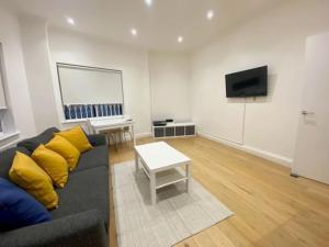 a living room with a couch and a flat screen tv at 2 Bedroom Flat in Whitechapel! in London