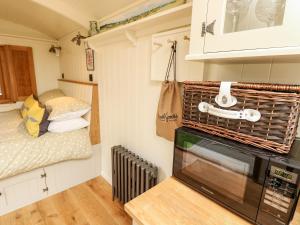 a small kitchen with a microwave and a bed at The Happy Hut in Christchurch