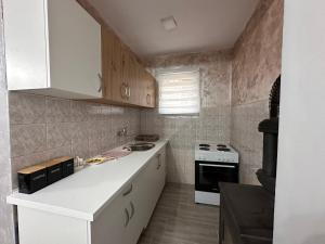 a kitchen with white cabinets and a stove top oven at Apartman ALEA in Pale