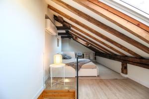 1 dormitorio con 1 cama en un loft con vigas de madera en Designer duplex in the center, en Santander