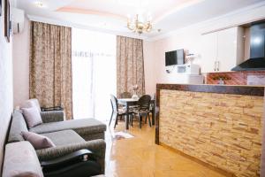 a living room with a couch and a table with chairs at Ekaterine's Apartments in Batumi