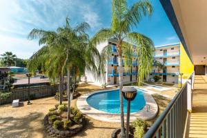 a view from the balcony of a hotel with a pool and palm trees at Tropical Tranquility - Corcega in Stella