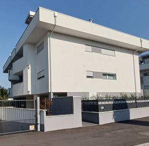 a white building with a fence in front of it at Bilocale a Rho in classe A con Garage in Rho