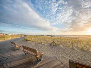 two benches sitting on a boardwalk near the beach at Katwijk Center, 1 min away from the beach! in Katwijk aan Zee