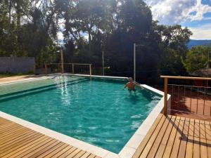 a man is standing in a swimming pool at Pousada Golf Village in Itaipava