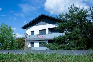 a white building with a sign on it at Apartments Silva in Ljutomer