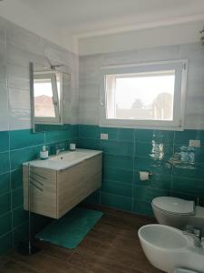 a green bathroom with a sink and a toilet at Bilocale a Rho in classe A in Rho