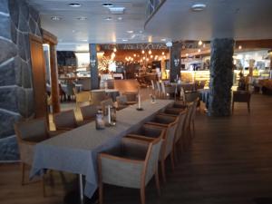 a dining room with a long table and chairs at Ellin Pooli 3 in Sastamala