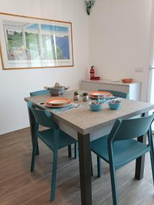 a dining room table and chairs with plates and bowls on it at Bilocale a Rho in classe A con Garage in Rho