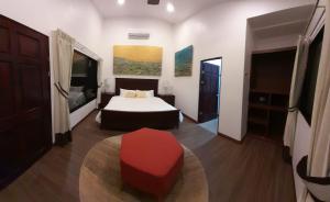 a bedroom with a bed and a red stool at Drake Bay River View in Drake